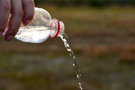 Pure fresh clear water is poured from a plastic bottle.