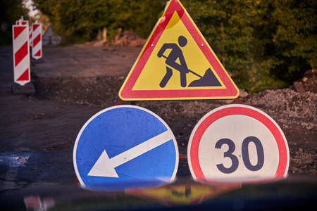 Repairs on the asphalt road, road signs, view from the car.の写真素材