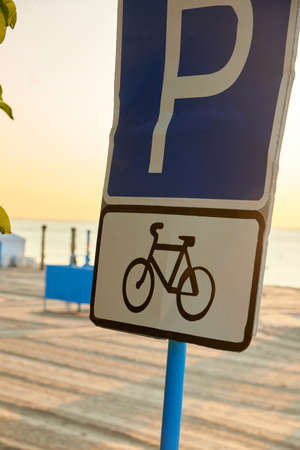 Blue bike parking sign on the sea beach.の写真素材
