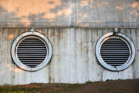 Large ventilation circles on an old destroyed wall.の写真素材