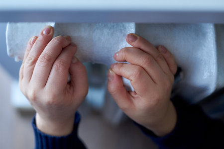 Female hands lie on the radiator, the concept of the heating season.の写真素材