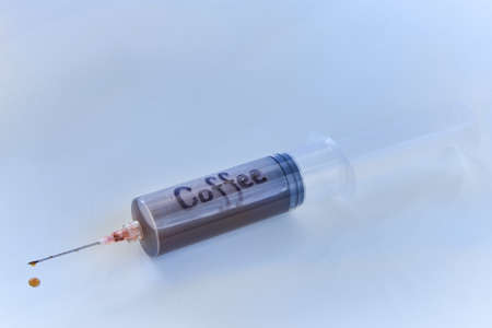 Syringe filled with coffee on white background, coffee addiction concept.の写真素材