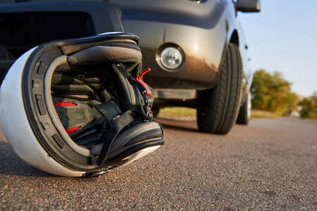 Photo of car, helmet and motorcycle on road, the concept of road accidents.の写真素材