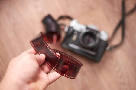 A man holds a negative from an old film camera, close-up.の写真素材