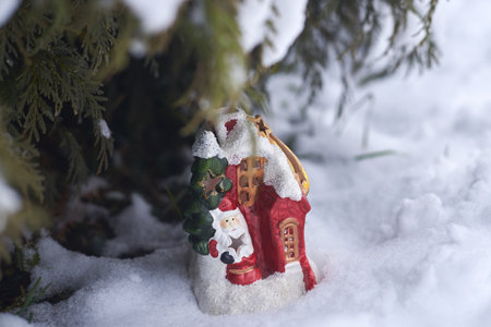 Christmas and New Year decoration, porcelain house with Santa Claus in the snow.