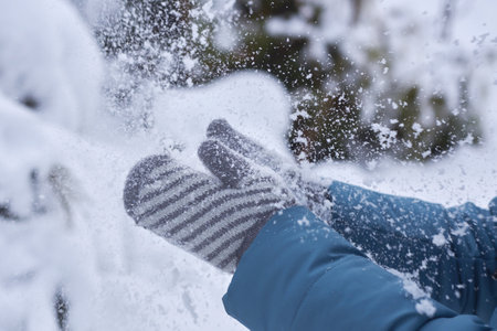 Woman in mittens claps hands in the snow.の写真素材