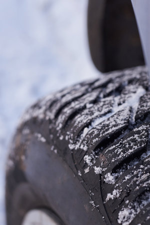 Car wheel in the snow in winter, close-up.の写真素材