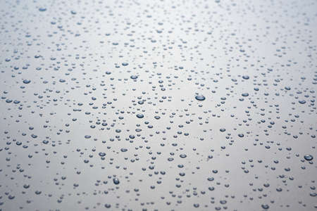 Small drops of water on a gray background, creative background.の写真素材