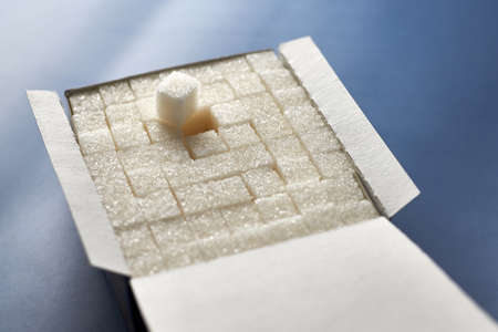 Heap of white sugar cubes on a blue background.の写真素材