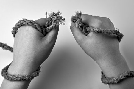 Tearing rope in the hands of a woman, liberation concept, black and white photo.