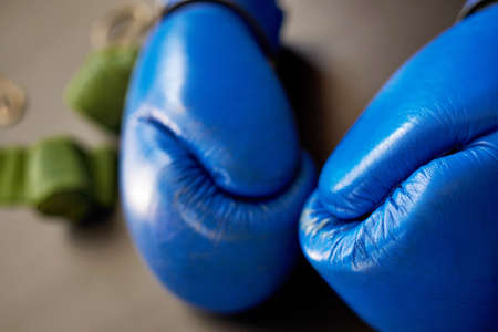 Blue leather boxing gloves, sports bandagesout of focus, close-up.の写真素材