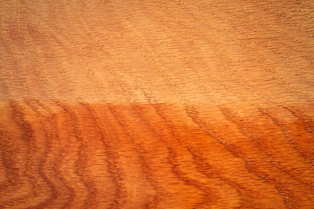 The oak board is half varnished, texture, close-up.の写真素材