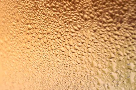 Bright drops on glass, orange creative background, close-up.の写真素材