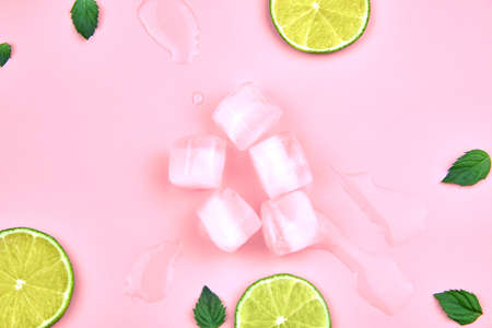 Flat lay composition, ice, mint and lime on a pink background.の写真素材