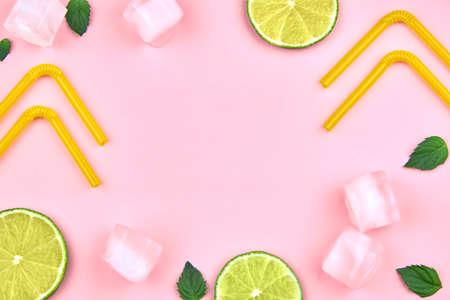 Flat lay composition, ice, mint, lime and tubes for drinking on a pink background, copy space.の写真素材