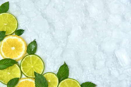 Pieces of lime, lemon and mint leaves on ice, copy space.の写真素材
