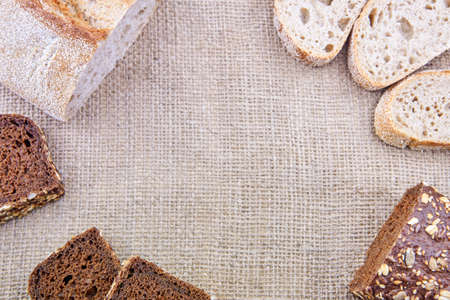 Different types of freshly baked sliced bread on sacking, copy space.の写真素材