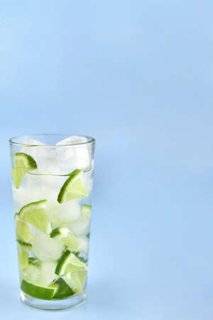 Glass with ice and lime on a blue background, copy space.の写真素材