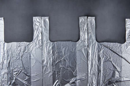 Three plastic bags on dark background, environmental pollution concept.