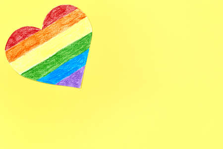 Paper heart painted in LGBT colors on a yellow background, copy space.の写真素材