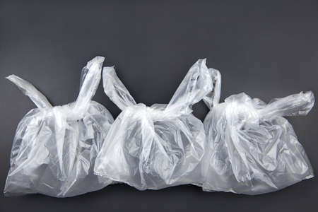 Three plastic bags on dark background, environmental pollution concept.の写真素材