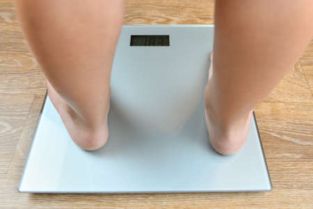 The feet of a three-year-old boy on the scales.
