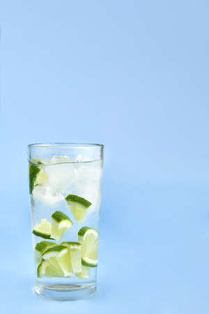 Glass with ice and lime on a blue background, copy space.の写真素材