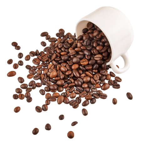 Roasted coffee beans spilling out of a cup isolated on white background.の写真素材