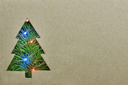 Paper box with a cut out figure of a Christmas tree, Christmas gift delivery concept, copy space.の写真素材