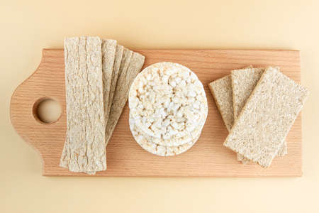 Different types of crispbreads on a wooden board, top view.の写真素材