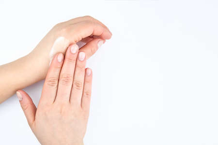 A woman moisturizes her hands with a protective cream, copy space.の写真素材