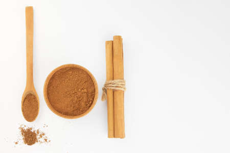 Ground cinnamon in a wooden bowl and cinnamon sticks, copy space.の写真素材