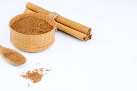 Ground cinnamon in a wooden bowl and cinnamon sticks, copy space.の写真素材
