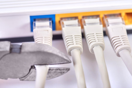 Wire cutters cuts the Internet cable into the router, close-up.の写真素材