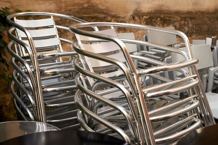Stacked iron chairs for an outdoor cafe on the street.の写真素材