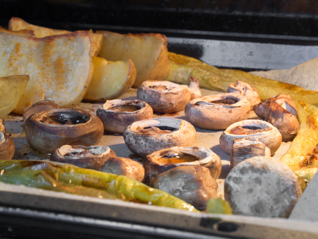 mushrooms, potatoes and green peppers cooked in the ovenの写真素材