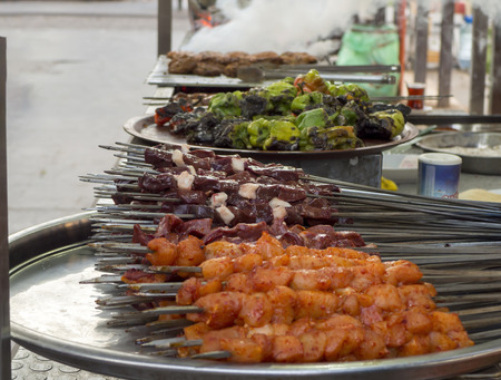 Turkish shish kebab on the street. liver, chicken, meatballs and pepper on the counter topの写真素材