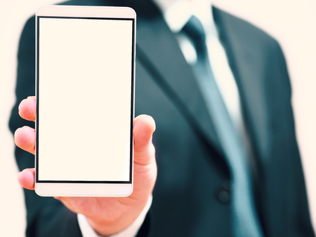 Businessman holding a phone in his hand. smart phone with blank screen for concept ideasの写真素材