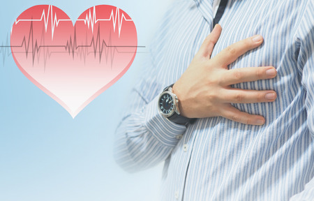 man holding his heart with his handの写真素材