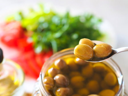 homemade green olives. close-up of organic olives and olive oil in jarの写真素材