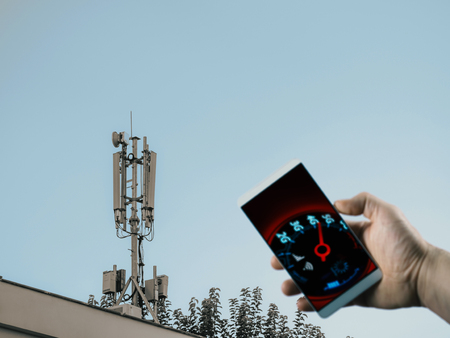 cell phone base station on roof and mobile network speedometer on phone screenの写真素材