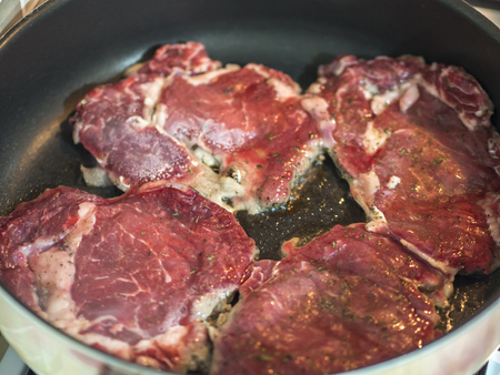 red beef steak being cooked in pan close-upの写真素材