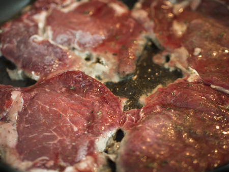 red beef steak being cooked in pan close-up viewの写真素材