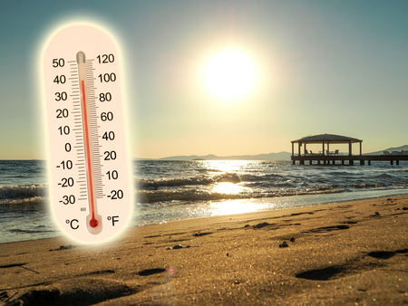 thermometer showing the temperature rise in the summer sun and seaside photo konceptの写真素材