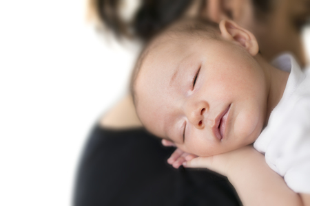 baby sleeping on mother shoulder. with white backgroundの写真素材