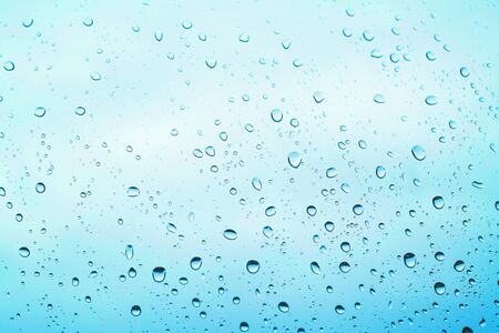 of rain standing on a glass. water droplets on glass with blue background