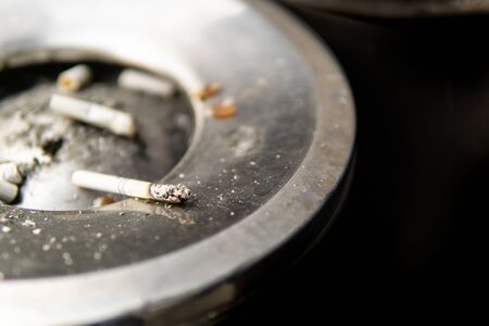 cigarette butts and black background in metal ashtrayの写真素材