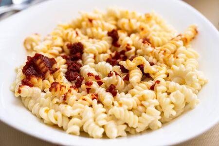 pasta with yogurt and tomato sauce in a white plate, turkish mealの写真素材