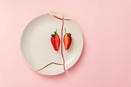 Strawberry cut in half in a broken plate. image explaining the dish and table layoutの写真素材