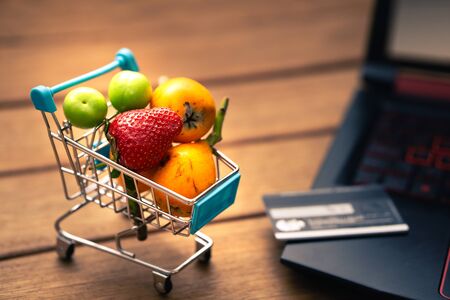 various fruits in the shopping cart, online shopping at homeの写真素材